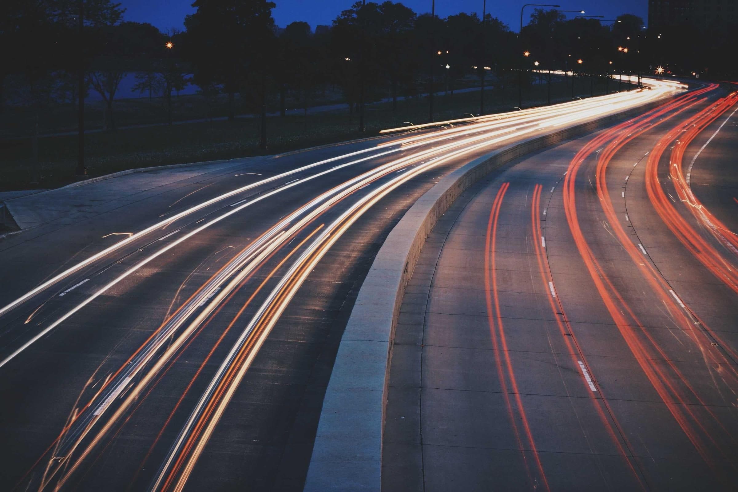 Světelné stopy aut na večerním nábřeží